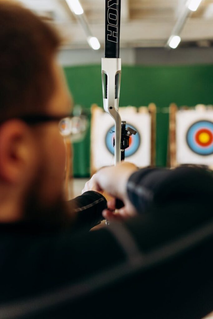 Archer aiming at targets indoors, showcasing concentration and skill.